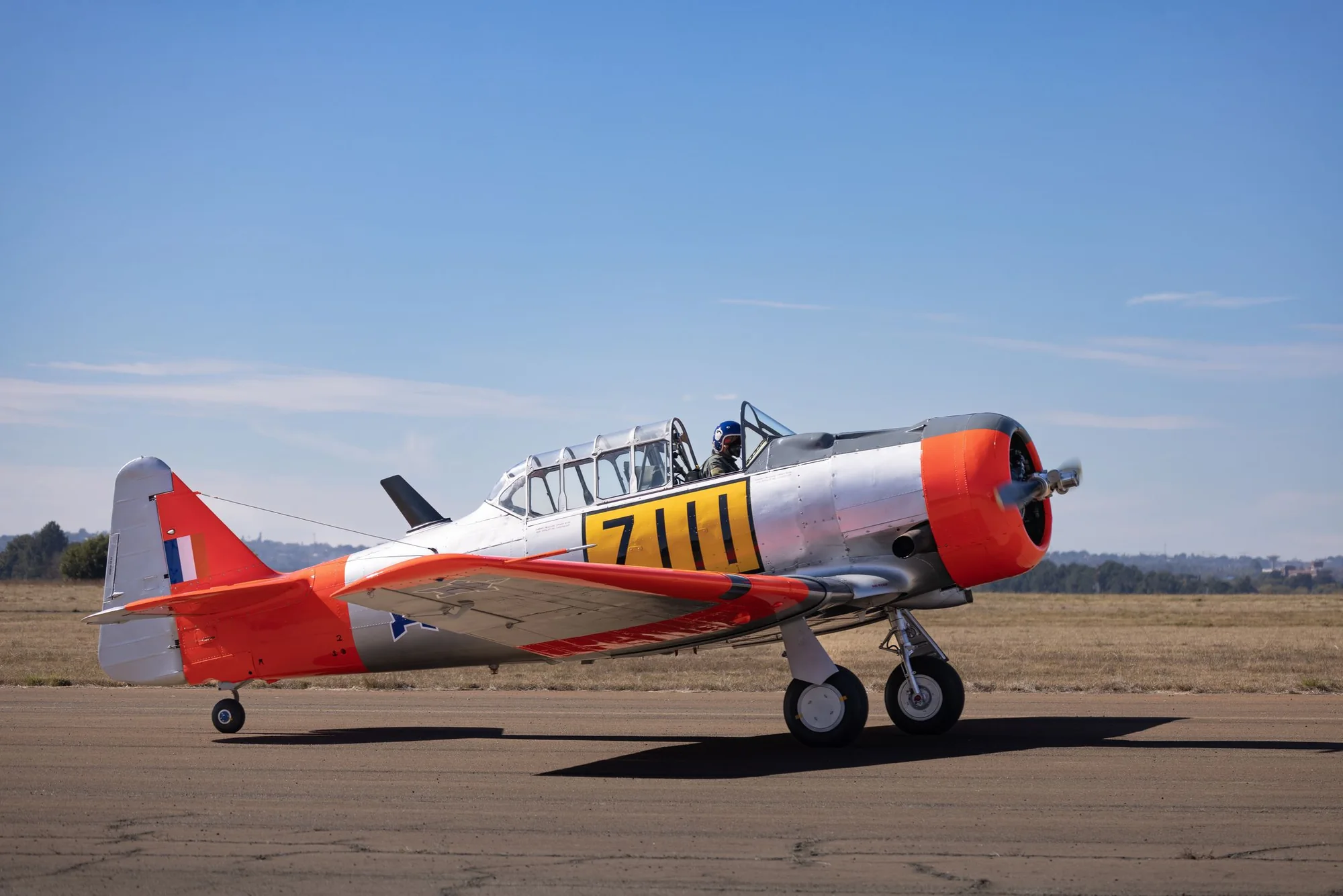 A vintage trainer aircraft on a runway